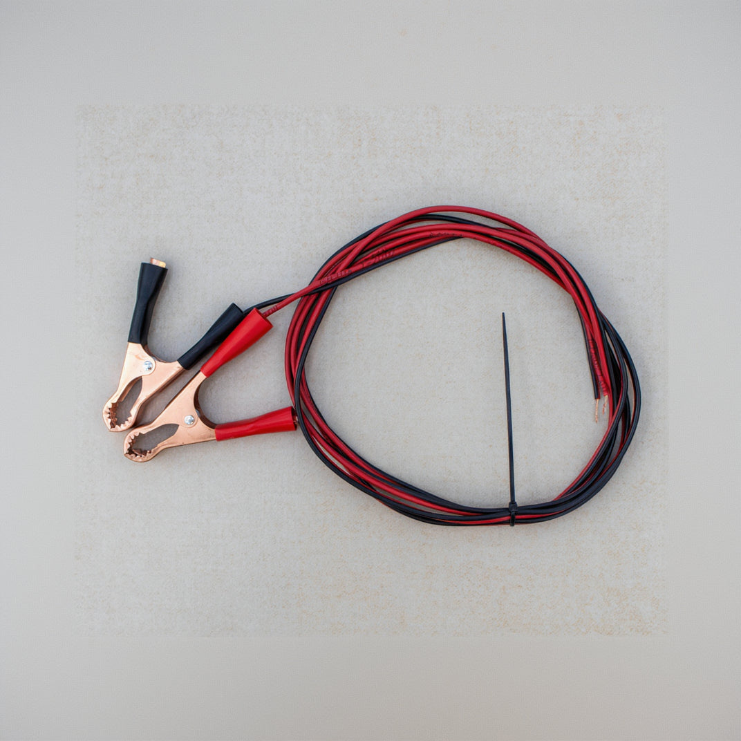 Jumper cables with red and black wires on a gray surface