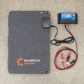 Solar panel with cables and battery on a gray surface